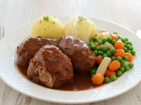 Fränkische Schweinebäckchen in dunkler Biersauce serviert