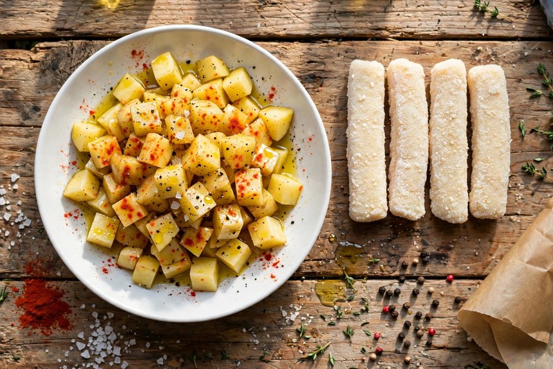 Kartoffelstücke, gewürzt mit Paprikapulver, Salz und Olivenöl – bereit für den Airfryer