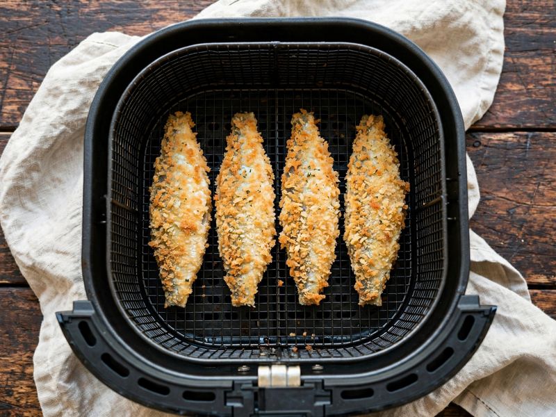 Sardinen liegen in einer einzelnen Schicht im Airfryer-Korb